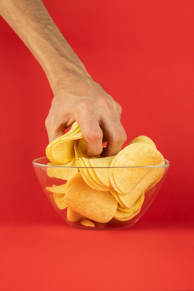 Hand grabbing tenis against a red background.
