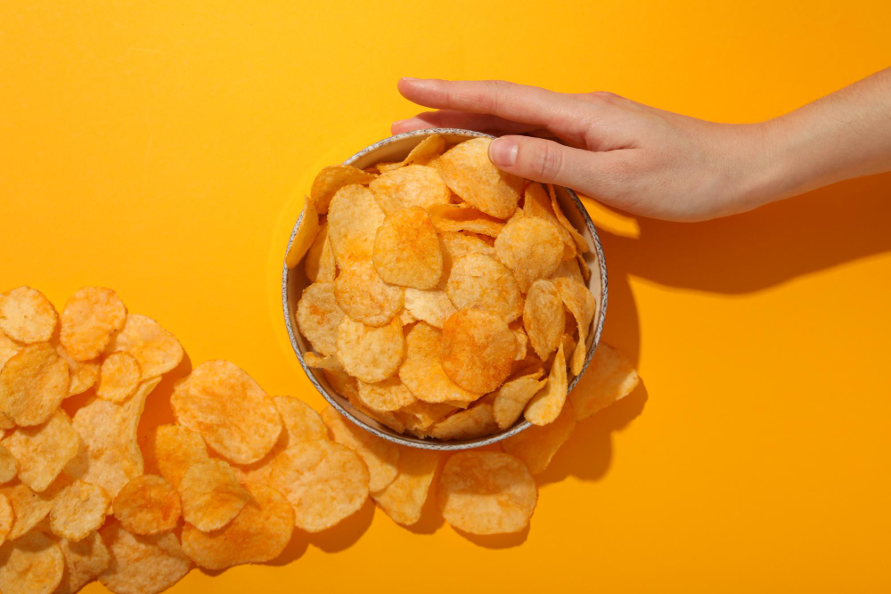Hand reaching into a bowl filled with POTATO SHOP tenis.