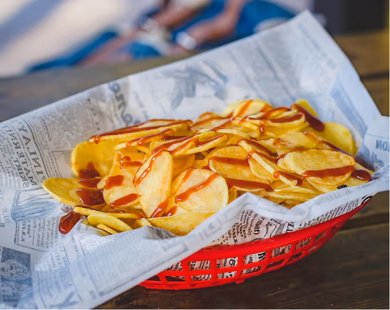 Basket filled with baked potato tenis served on a table.